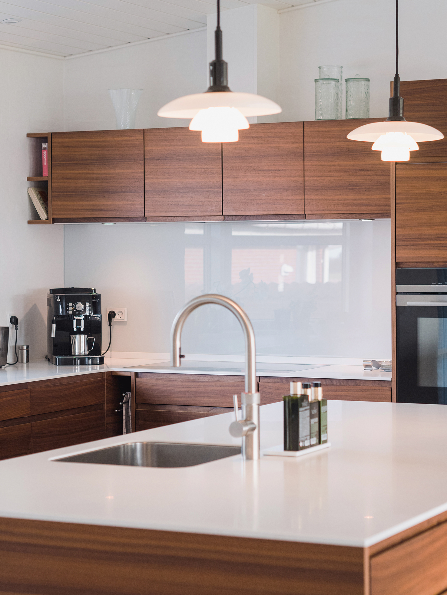 Køkken i valnød med varm, naturlig elegance og minimalistiske linjer, hvor materialernes kvalitet skaber et eksklusivt og roligt udtryk.