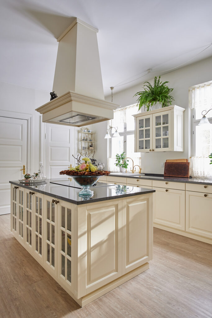 Antique Lifestyle-køkken med vitrineskabe i køkkenøen – lyst, luftigt og holdbart køkken, der fungerer perfekt i dagligdagen.