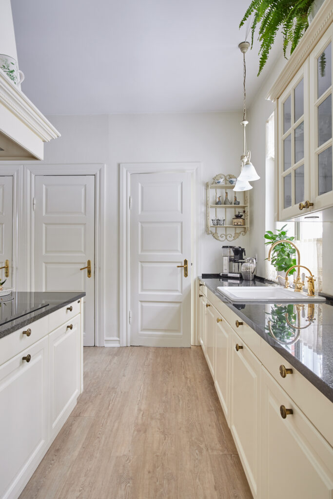 Antique Lifestyle-køkken med vitrineskabe i køkkenøen – lyst, luftigt og holdbart køkken, der fungerer perfekt i dagligdagen.