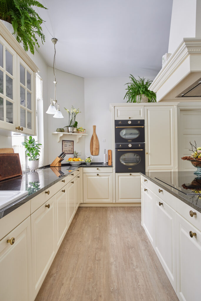 Antique Lifestyle-køkken med vitrineskabe i køkkenøen – lyst, luftigt og holdbart køkken, der fungerer perfekt i dagligdagen.