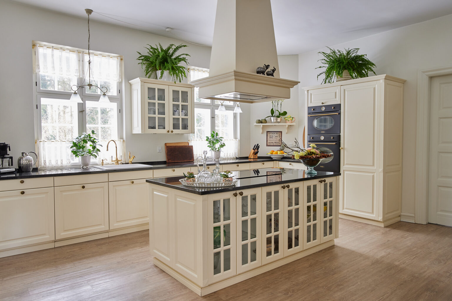 Antique Lifestyle-køkken med vitrineskabe i køkkenøen – lyst, luftigt og holdbart køkken, der fungerer perfekt i dagligdagen.