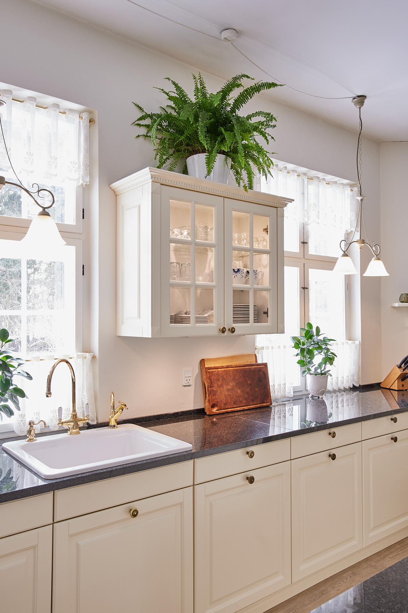 Antique Lifestyle-køkken med vitrineskabe i køkkenøen – lyst, luftigt og holdbart køkken, der fungerer perfekt i dagligdagen.