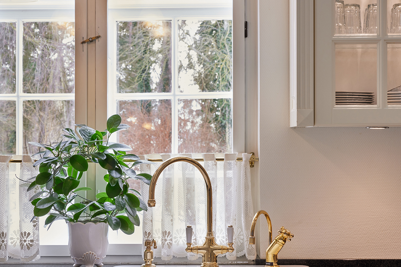 Antique Lifestyle-køkken med vitrineskabe i køkkenøen – lyst, luftigt og holdbart køkken, der fungerer perfekt i dagligdagen.